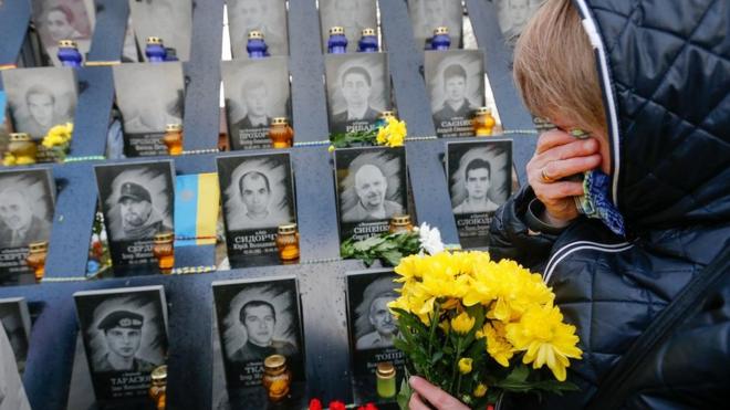 Жінка біля пам'ятних дошок загиблих на Майдані