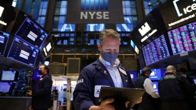 A trader in a face mask works on the trading floor at the New York Stock Exchange (NYSE) as the Omicron coronavirus variant continues to spread in Manhattan, New York City, U.S., December 20, 2021