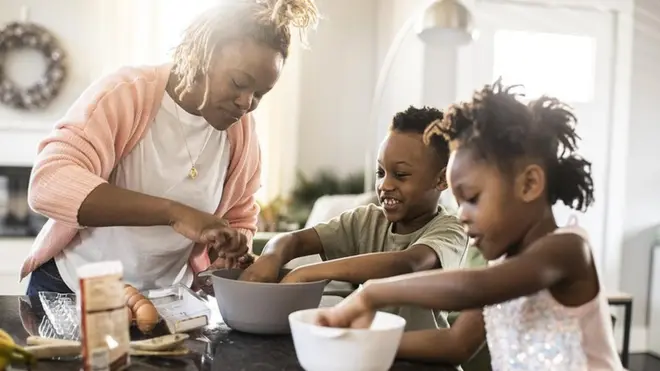 Les changements dans le cerveau des mères peuvent durer des années. Une mère cuisinant avec son fils et sa fille