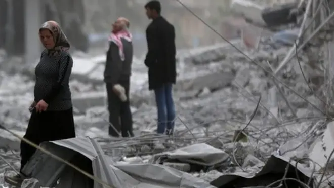 سكان في عفرين يمشون وسط الأنقاض