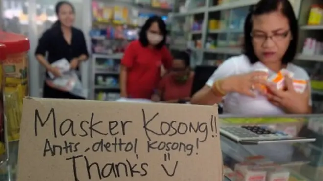Karyawan apotek memajang tulisan pemberitahuan kehabisan stok masker dan produk cairan antiseptik di Denpasar, Bali, Selasa (3/3/2020). Sejak meluasnya wabah virus corona dari Wuhan, China stok masker dan cairan antiseptik di sejumlah pedagang di Bali mulai langka.