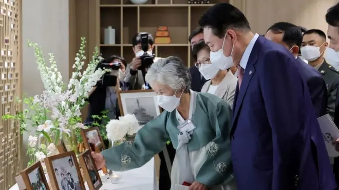 윤석열 대통령과 천안함 희생자 고 민평기 상사 모친 윤청자 여사가 9일 서울 용산 대통령실 청사에서 열린 '호국영웅 초청 소통식탁' 행사에서 아들 민 상사의 사진을 보고 있다