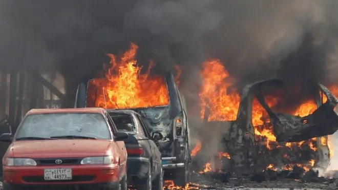 अफ़ग़ानिस्तान के जलालाबाद में हुए धमाके के बाद कारों में लगी आग
