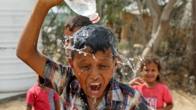 A child tries to cool himself in a heatwave in Gaza