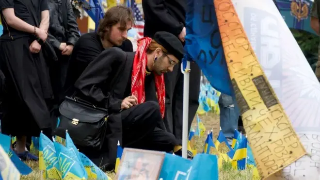 Rodion postavlja zastavicu za bivšeg dečka koji je poginuo u ranim stadijumima rata u Ukrajini