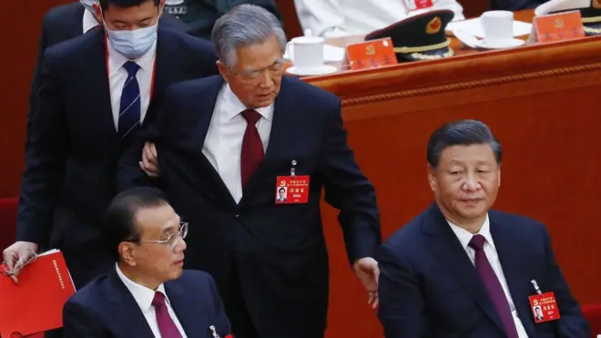 Hu Jintao (centre) was sitting next to his successor Xi Jinping (right) before being escorted out