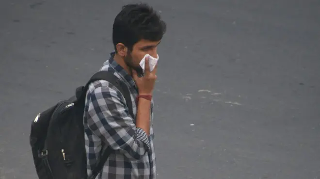 Hombre tapándose la nariz en Delhi