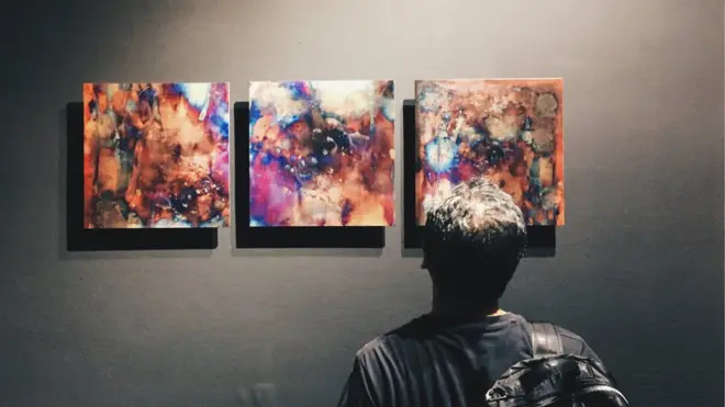 Seorang pengunjung pameran menikmati Transcientraces, karya Lie Fhung yang merupakan dokumentasi dari proses oksidasi tembaga