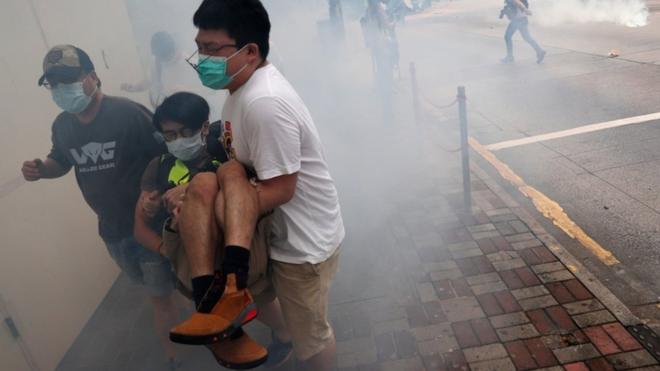 Anti-government protesters run away from tear gas during a march against Beijing's plans to impose national security legislation in Hong Kong, 24 May 2020
