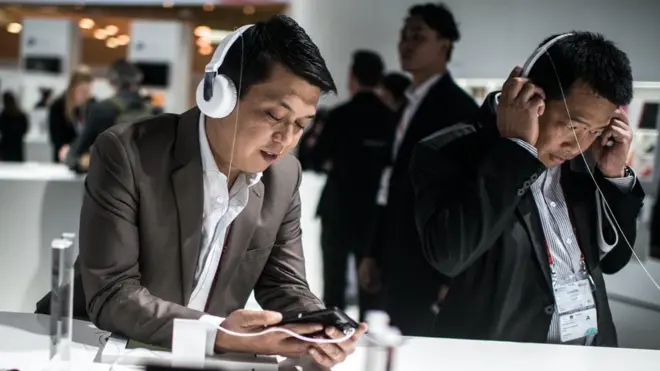 ผู้ชายกำลังฟังเพลงด้วยหูฟัง