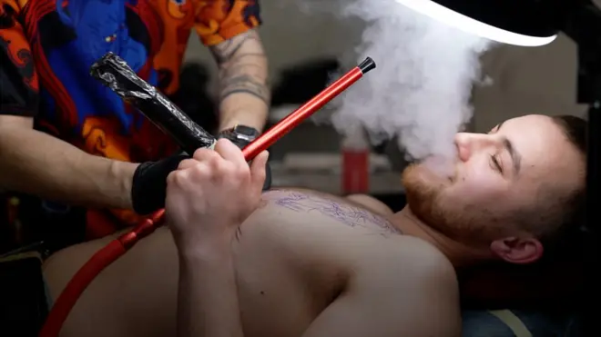 烏克蘭利沃夫一家紋身館內正在接受刺青的一位男士