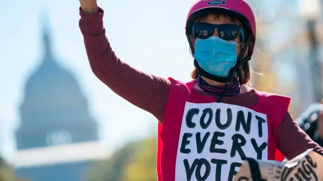 A demonstrator bikes by the US Capitol building