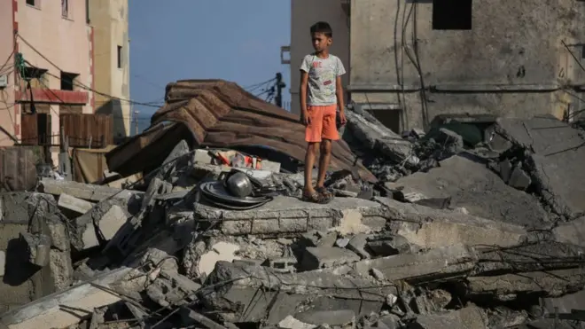 طفل يقف على انقاض منزل اسرته في غزة