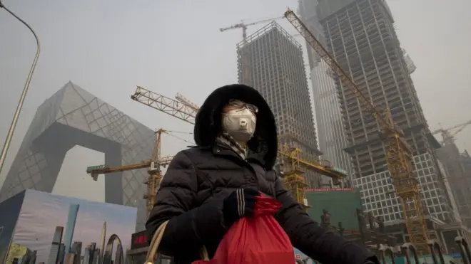 Kabut asap menyelimuti Kota Beijing, Cina, sehingga warga harus mengenakan masker untuk menjalani aktivitas di luar ruangan.