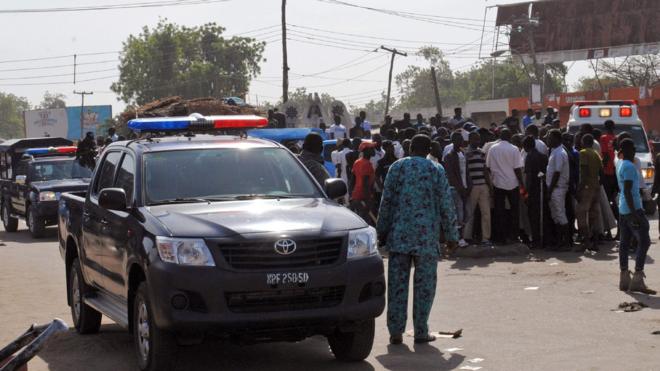 Emergency services, police and residents gather at scene of suicide bomb attack on a market in Maiduguri. 11 Dec 2016