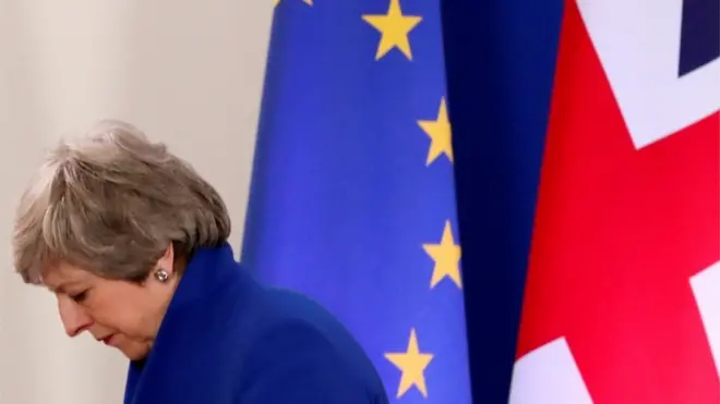 Тереза Мей поруч з прапорами ЄС та Британії