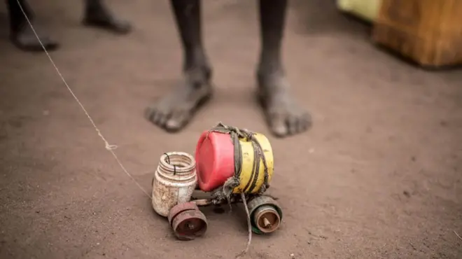 A boy plays with a toy car in Rhino refugee camp in northern Uganda. Such cars, made from bootle caps and other waste plastic, are seen throughout the camps. No two are ever quite the same.
