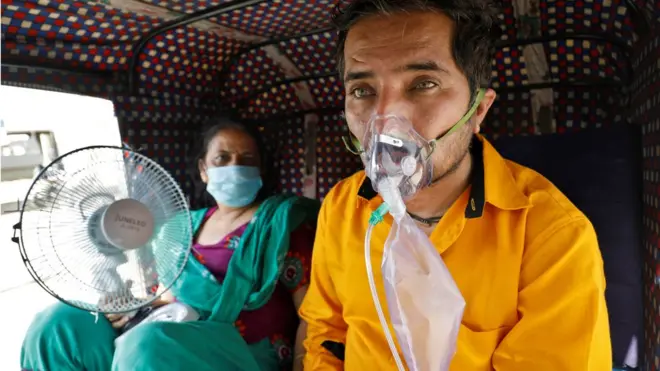 A patient in an auto-rickshaw waiting to be allowed into a hospital in the city of Ahmedabad