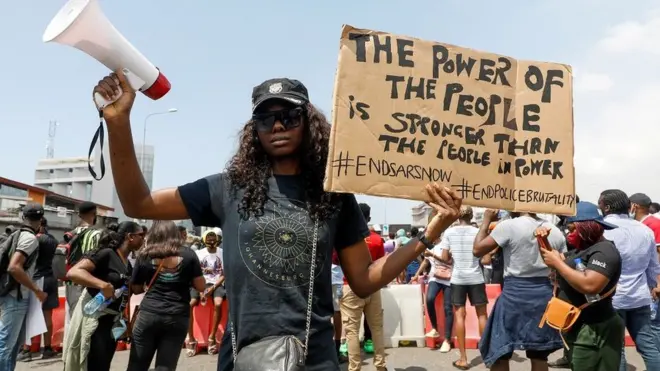 A demonstrator holds a banner during a protest against alleged police brutality, in Lagos, Nigeria