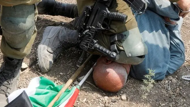 جندي إسرائيلي يجثو بركبته على رقبة ورأس حانون