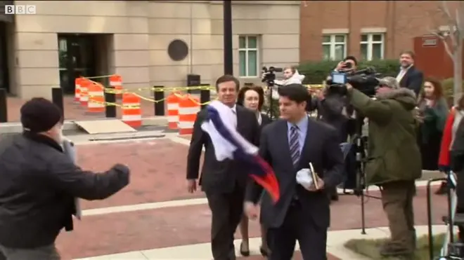 Чоловік жбурляє в Пола Манафорта російський прапор