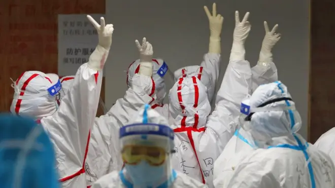 Медицинско особље се међусобно поздравља пре него што ће ући у одељење за интензивну негу пацијената заражених Ковидом-19 у Вухану, у Кини