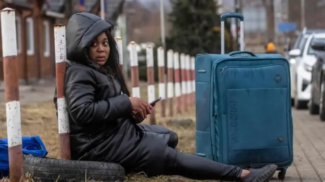 Une femme africaine est vue en train de se reposer à la frontière piétonne de Medyka, dans l'est de la Pologne, le 27 février 2022.