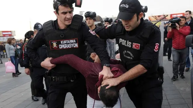 Polis bir eylemciyi gözaltına alırken