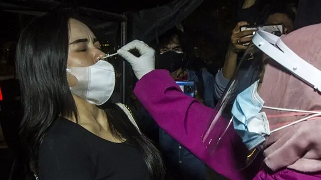 Petugas kesehatan melakukan tes usap antigen Covid-19 kepada pengguna jalan yang melintas di pos pengetatan pintu masuk Kota Banjarmasin, Kalsel, Selasa (24/08).