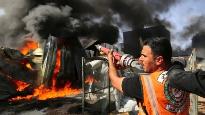 A Palestinian firefighter participates in efforts to put out a fire at a sponge factory on Monday