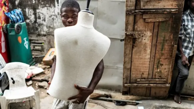 Man wey hold mannequin.