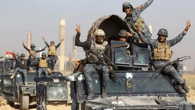 Iraqi forces make victory signs after taking control of a refinery on the outskirts of the city of Kirkuk on 16 October 2017