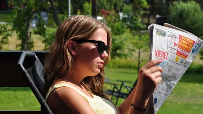 شابة تقرأ في صحيفة في النرويج