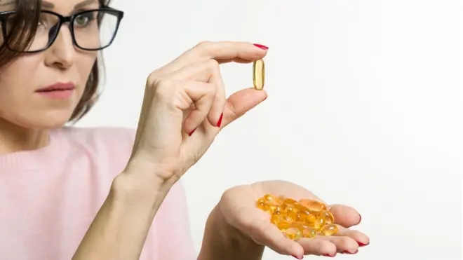 Mujer con una cápsula en la mano