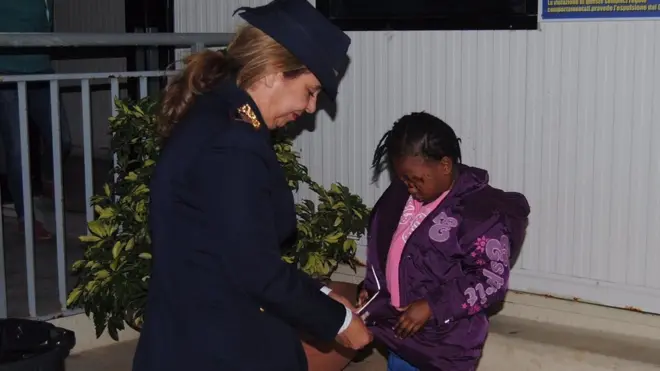 Polis memuru Maria Volpe Oumoh'ya montunu giydirirken