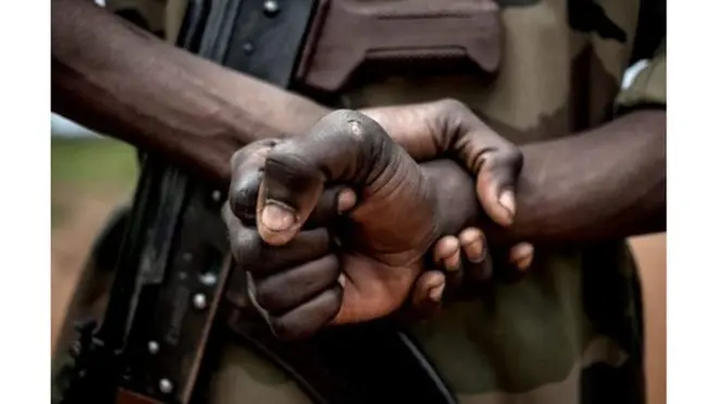 Photo d'archive d'un homme, de dos, tenant une arme
