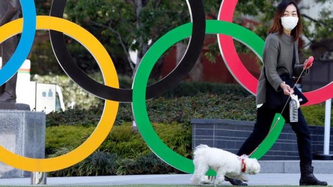 Woman with dog in front of Olympic rings