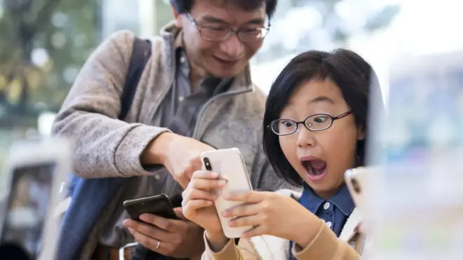 Девушка держит в руках iPhone X