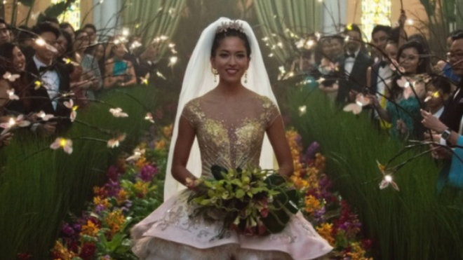Movie still from Crazy Rich Asians showing Sonoya Mizuno walking down the aisle in a wedding dress
