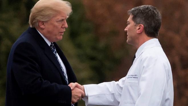 Donald Trump en un apretón de manos con el doctor Ronny Jackson.