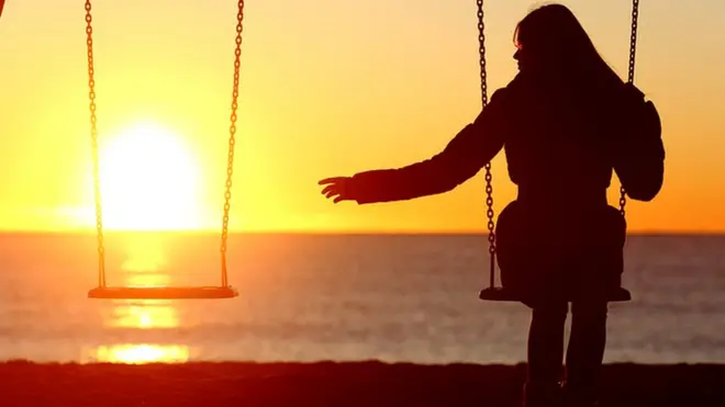 Одинокая девушка на качелях
