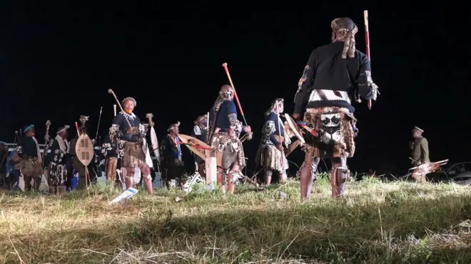 Zulu men wear traditional warrior outfits at night for Nongoma, South Africa - March 2021