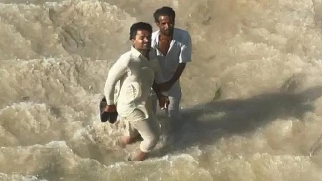 عباس احمد اور ان کے کزن ہیلی کاپٹر تک پہنچنے کی کوشش کر رہے ہیں