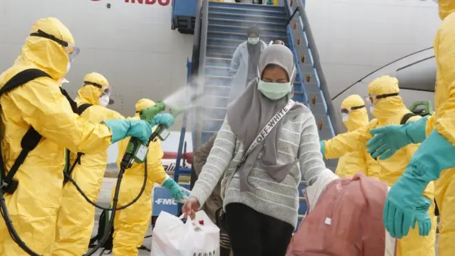 Petugas medis menyemprotkan cairan disinfektan pada Warga Negara Indonesia (WNI) dari Wuhan, China setibanya di Bandara Hang Nadim, Batam, Kepulauan Riau, Minggu (2/2/2020).