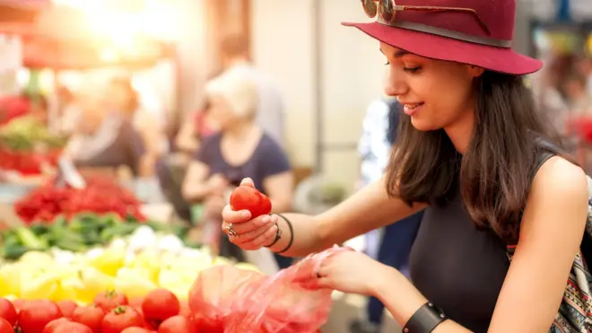 Модная девушка выбирает помидоры