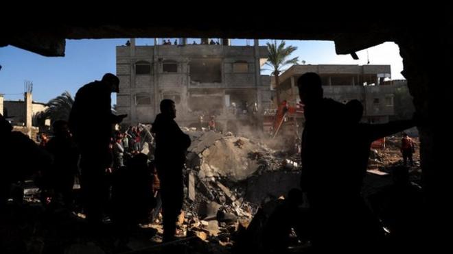 Palestinians search for causalities at the site of an Israeli strike on a house, amid the ongoing conflict between Israel and the Palestinian Islamist group Hamas, in Rafah, in the southern Gaza Strip, December 19, 2023.
