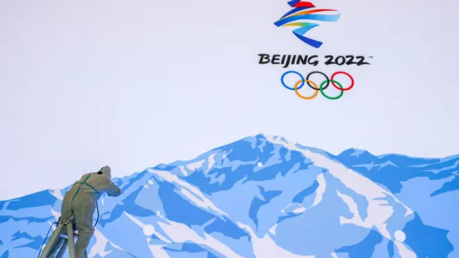 A worker makes repairs to a video wall at the Winter Olympics' Main Media Centre
