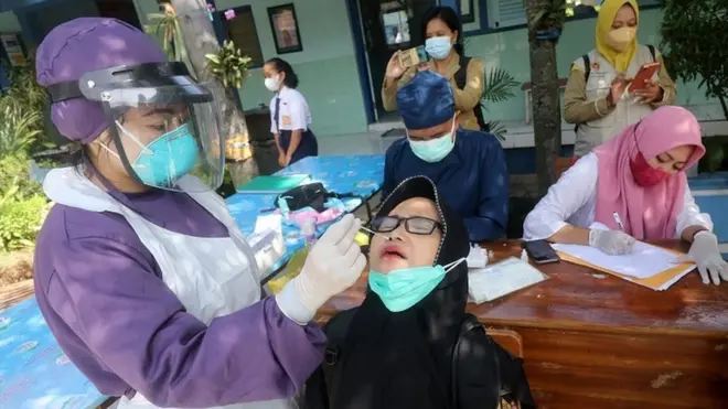 Petugas kesehatan melakukan swab test antigen kepada guru di SMPN 3 Kota Kediri, Jawa Timur, Senin (24/1).