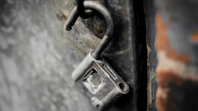Открытый замок на металлической двери