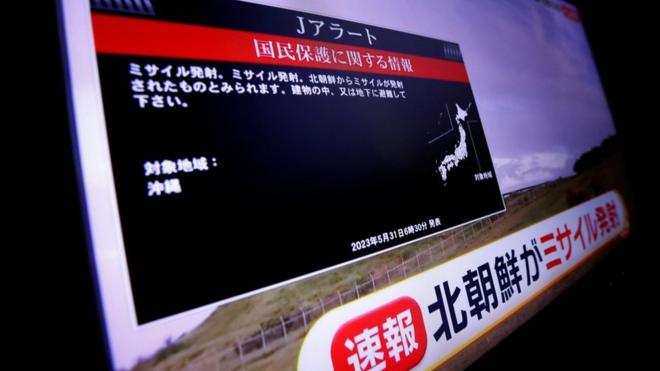 A TV screen displays a warning after the Japanese government issued an emergency warning to residents of Okinawa, saying a missile had been launched from North Korea